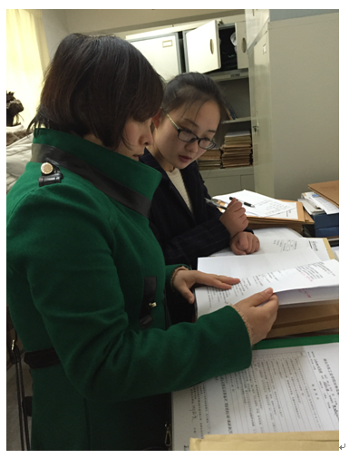 2015年新近教师覃玄参与期初教学检查,与青年教师讨论如何提高教学资料的规范性